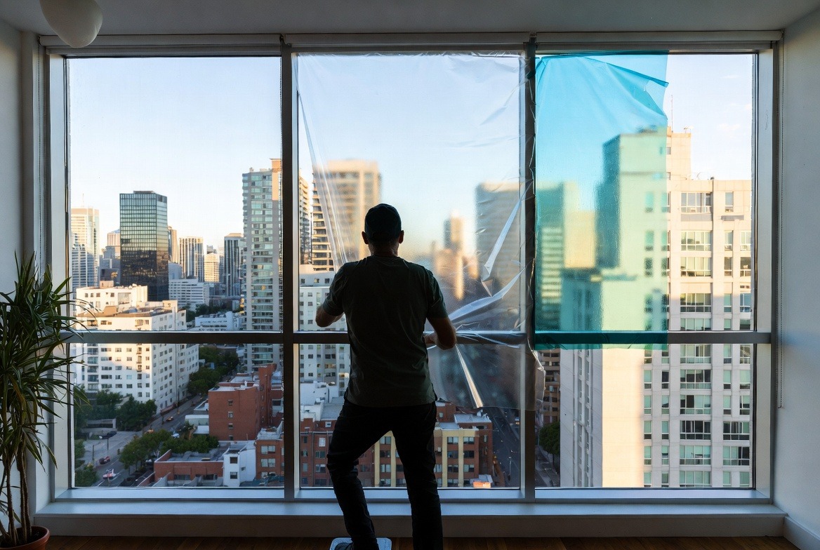 person-installing-window-film-on-glass