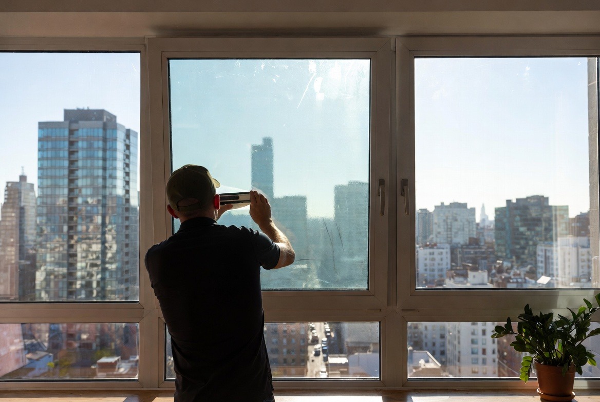 person-installing-window-film-on-glass